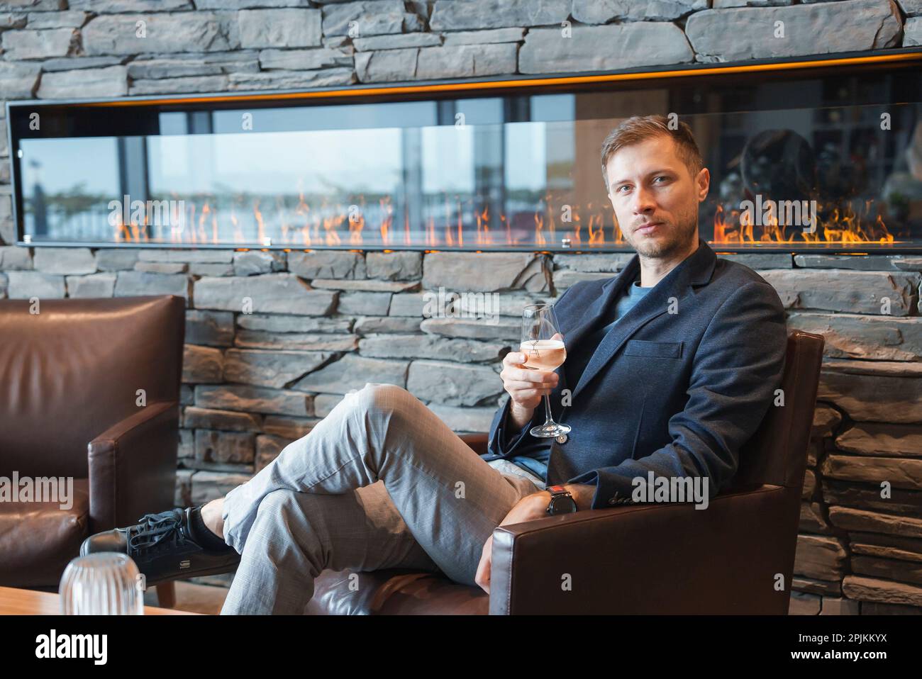 Man with wineglass sitting in chair at luxury hotel during vacation Stock Photo