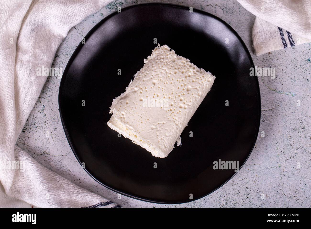 Clotted cream on gray background. Clotted cream (butter cream) for Turkish breakfast. local name inek kaymak. Top view Stock Photo