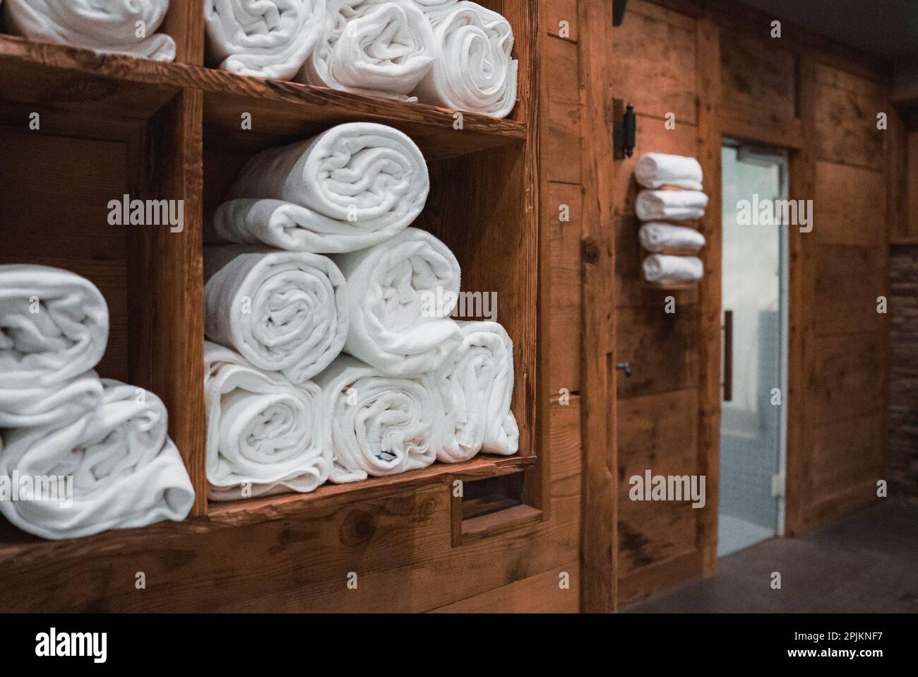 https://c8.alamy.com/comp/2PJKNF7/clean-white-towels-rolled-and-stacked-in-shelf-of-sauna-in-luxury-hotel-spa-2PJKNF7.jpg