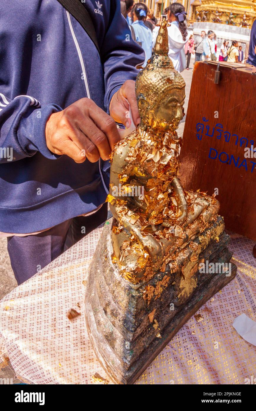 Thailand, Bangkok. Gold leaf offerings on Buddha statue at Wat Phra
