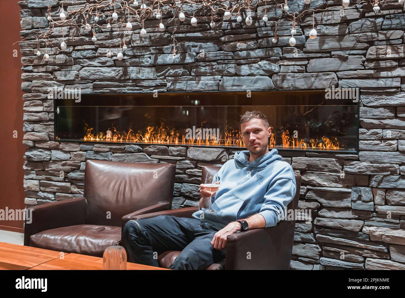 Man with wineglass sitting in armchair at luxury hotel during vacation Stock Photo
