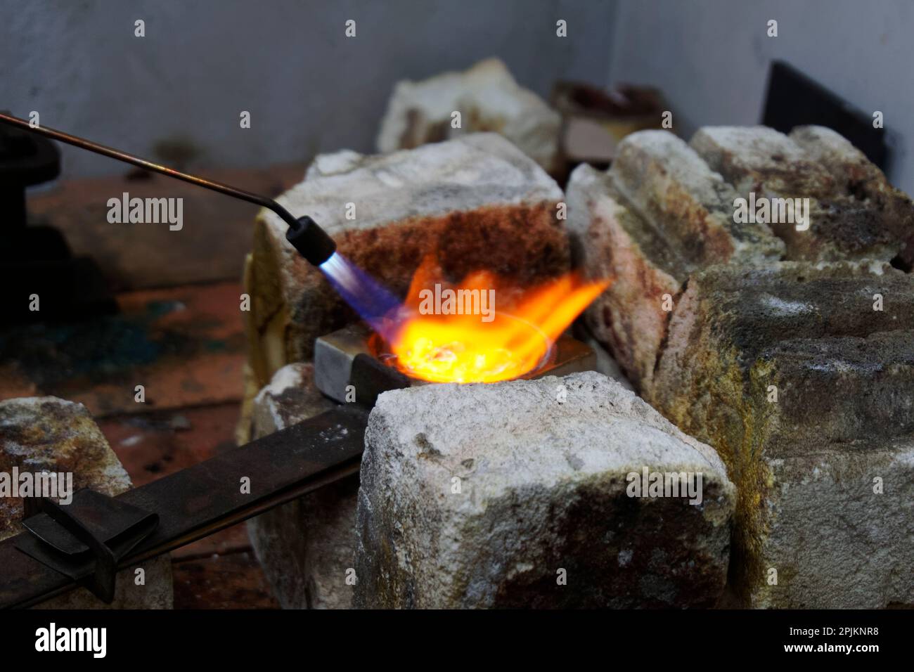 Flames are filling the crucible as silver is being melted down