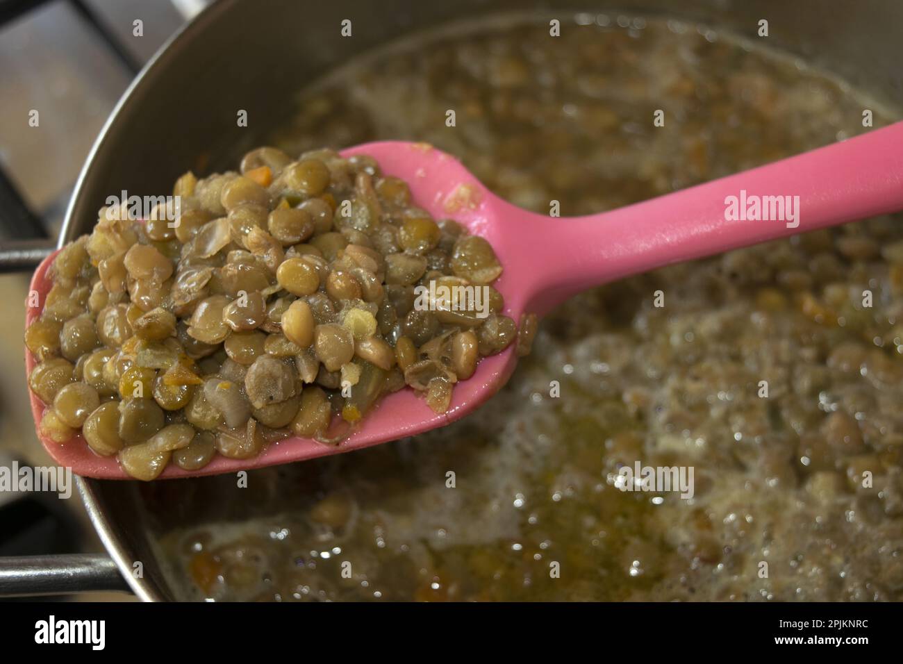 detail of a ladleful of lentils taken from a soup Stock Photo