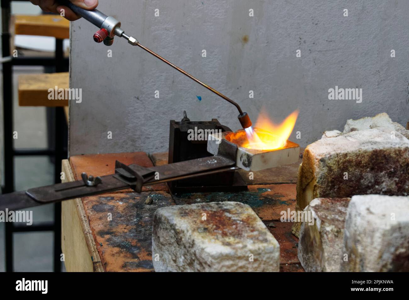 Melted silver is kept hot while it is transferred over to a mould to be cooled and reused Stock