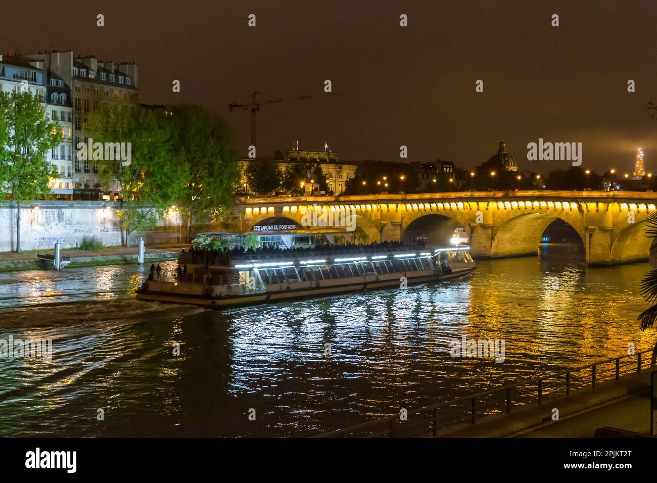 Paris. Bateaux Mouche boat on the canal at night. Stock Photo