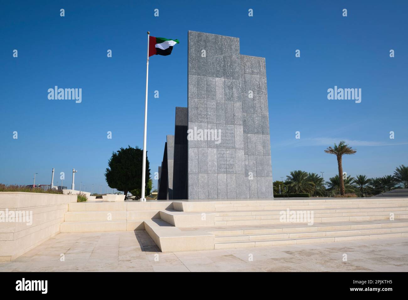 The nation's flag flying in front of the artwork. At the Wahat Al Karama memorial monument to fallen military, police, diplomats in Abu Dhabi, UAE, Un Stock Photo