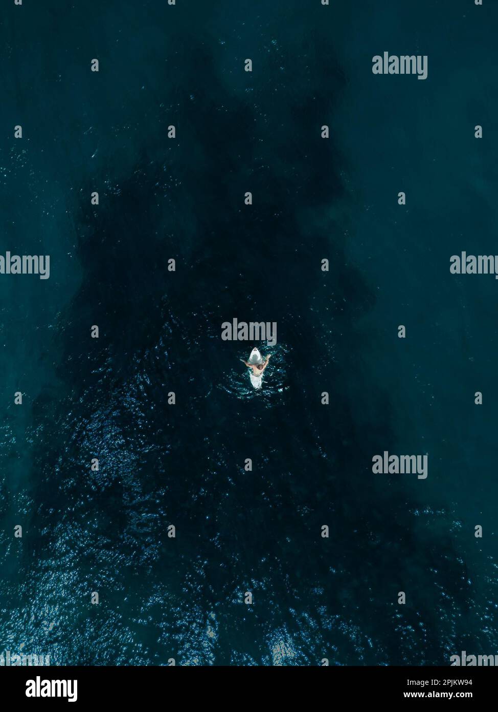 An aerial view of a small motorboat sailing in the vast blue expanse of ...