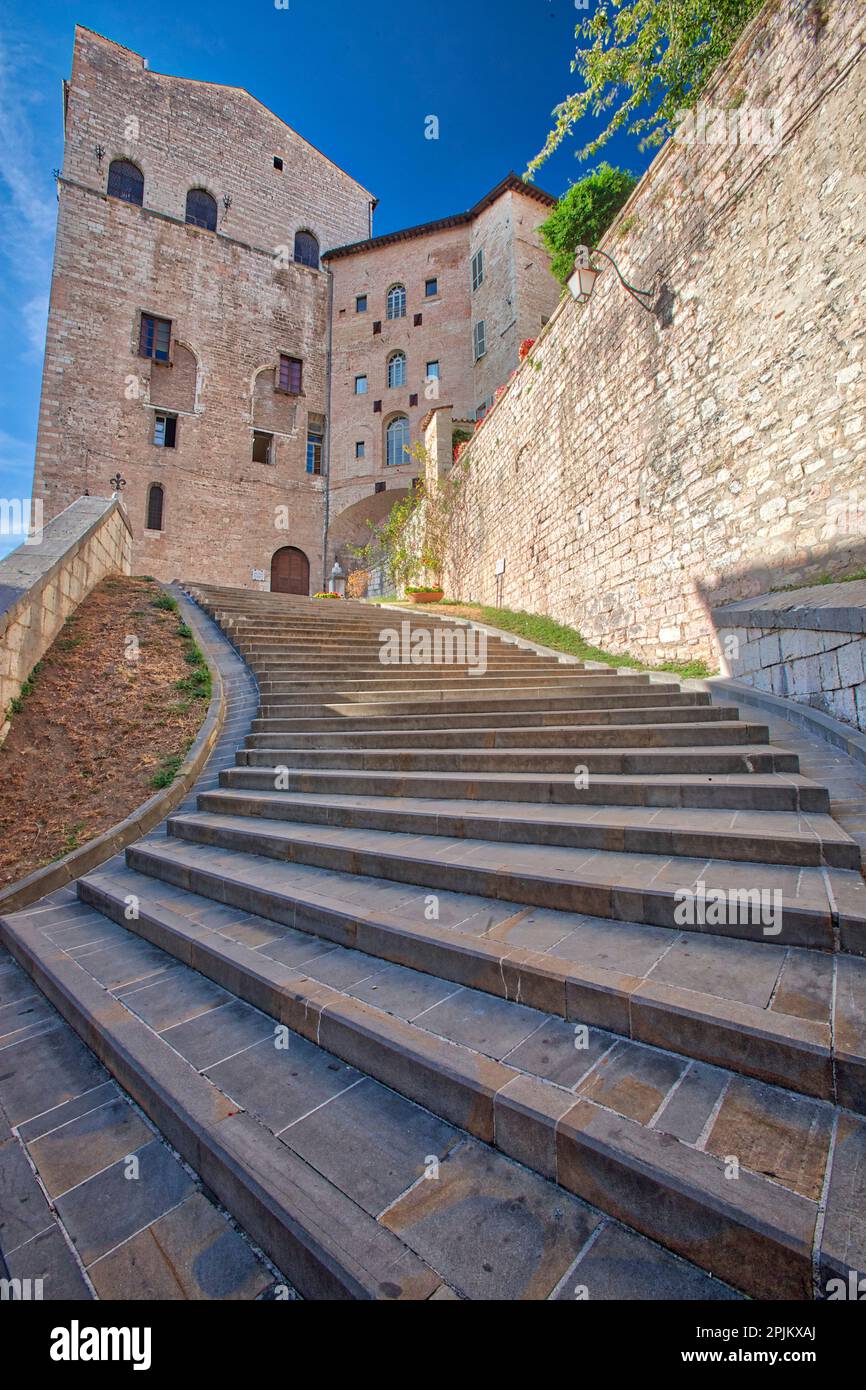 Italy, Umbria. Wide curved stairs leading up through the medieval town of Gubbio. Stock Photo
