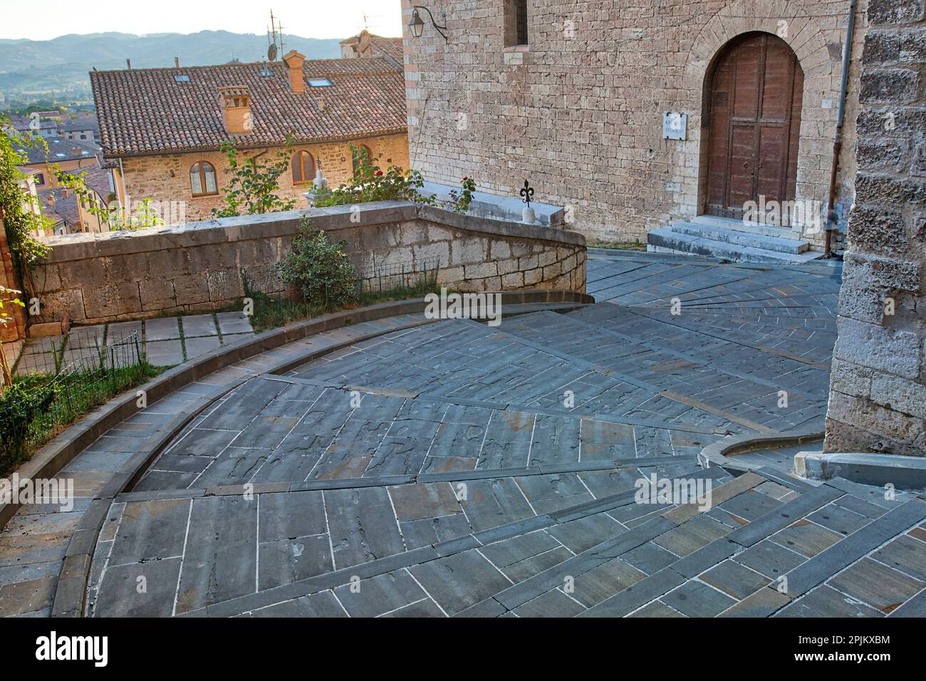 Italy, Umbria. Wide curved stairs leading down through the medieval town of Gubbio. Stock Photo