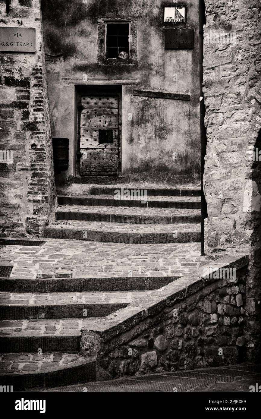 Italy, Umbria. Black and white photo of stairs leading to an old wooden door in the historic town of Montone. Stock Photo