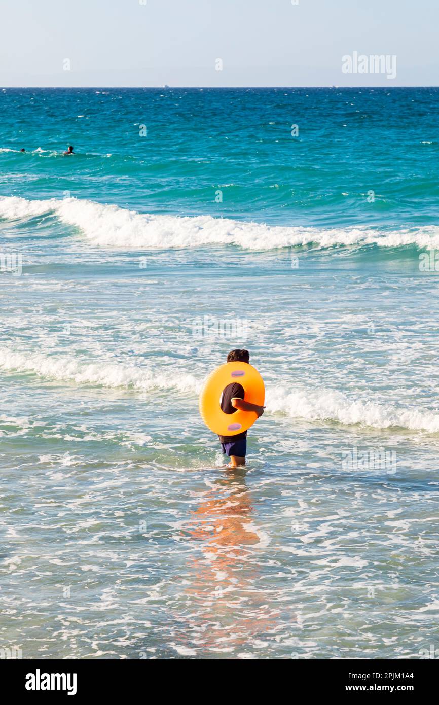 Playa El Tecolote, La Paz, Baja California Sur, Mexico. Boy wading into
