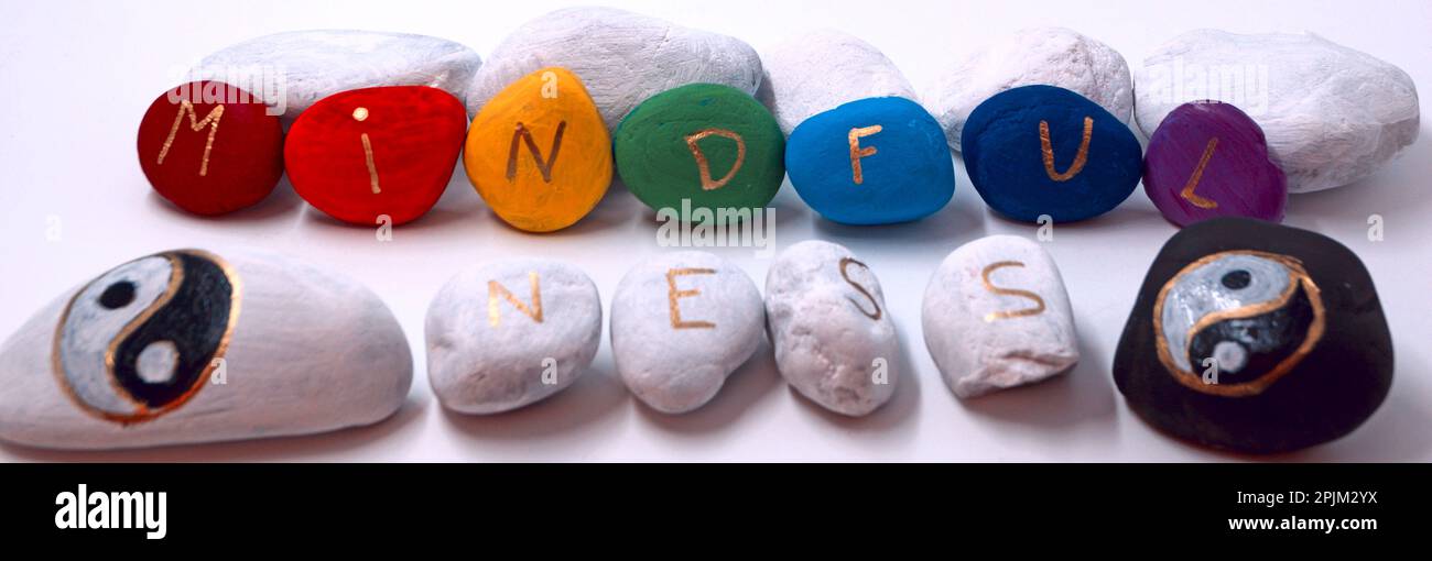 Mindfulness painted on colored stones with two yin yang stones Stock Photo