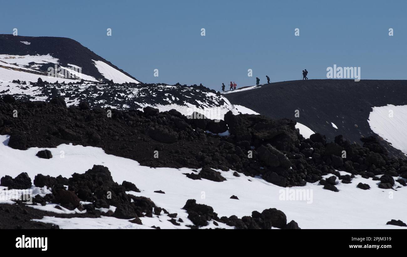 minimalist landscape with distant people silhouette walking in winter Etna National Park, Sicily, Italy Stock Photo