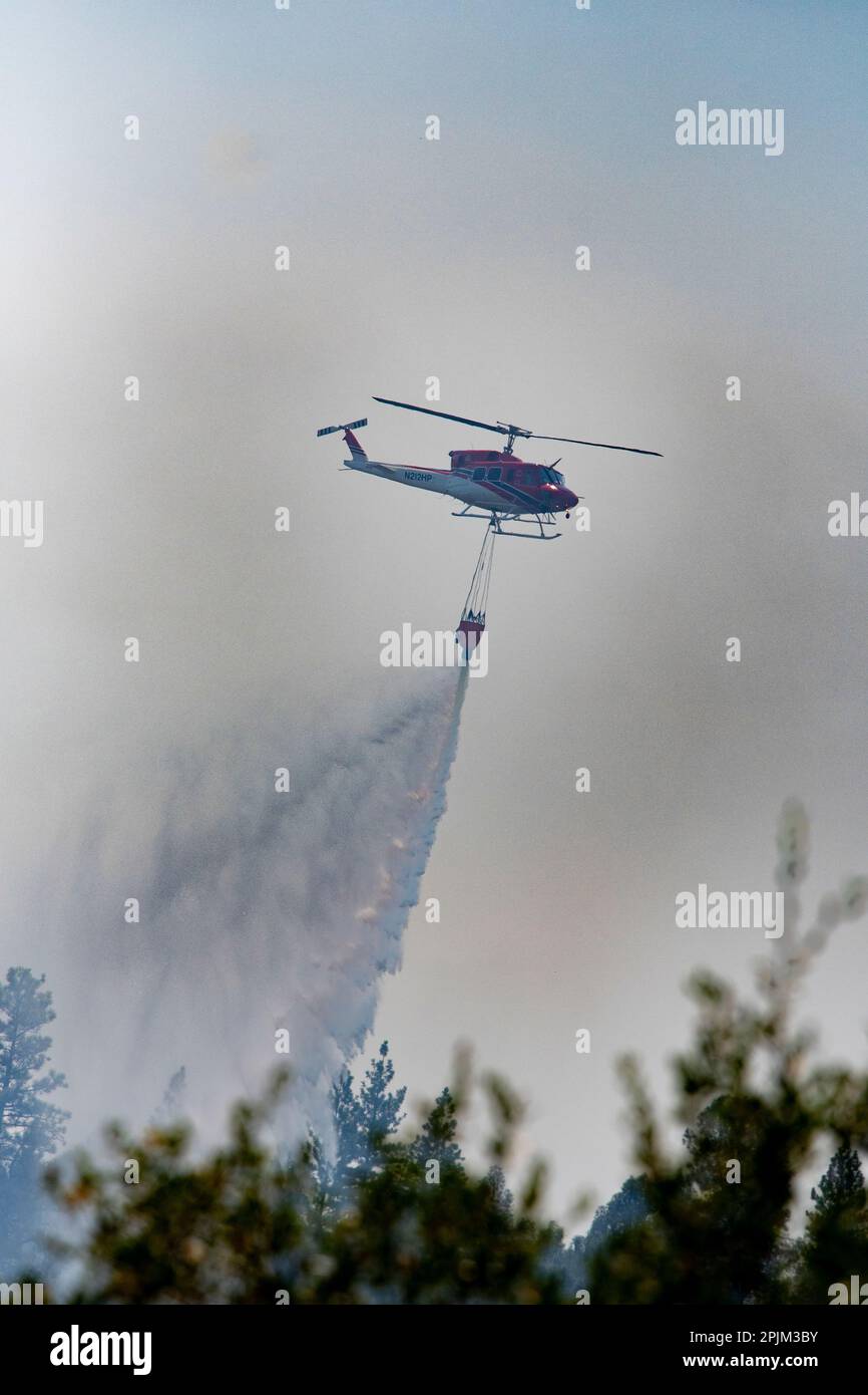 Helicopter drops water on a forest fire in the Sierra Nevada foothills. Stock Photo