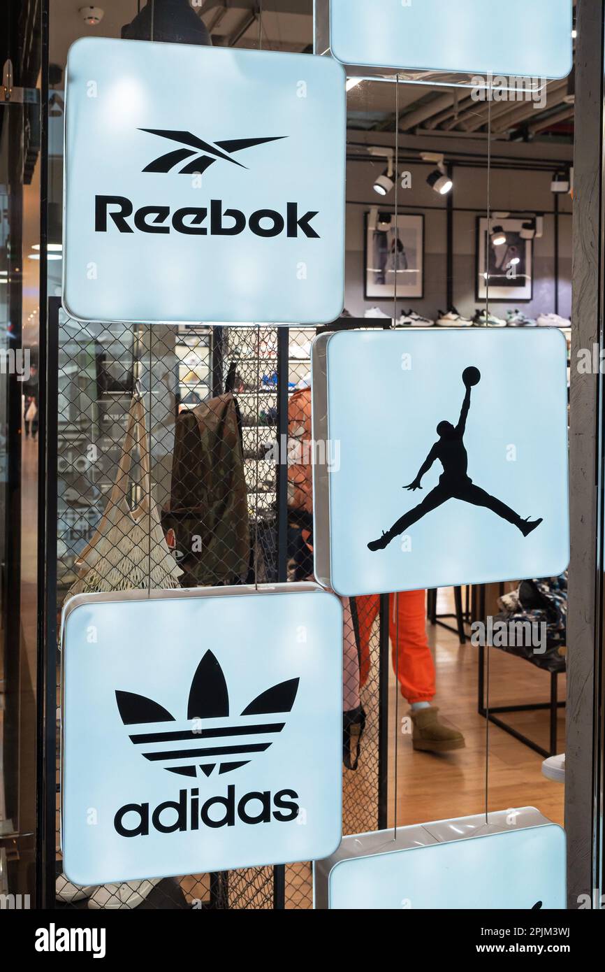 Reebok, Air Jordan, and Adidas logos of popular footwear and clothing brands in the interior of a multi-brand sport store. Minsk, Belarus, 2023 Stock Photo