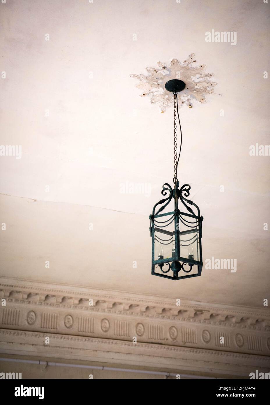 Hanging light fixture lantern with missing ornate details at Poltimore House, near Exeter in Devon in need of renovation in May 2019 Stock Photo
