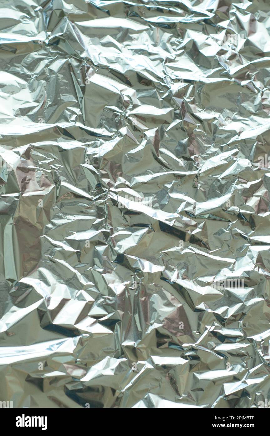 Metallic foil texture. Metallic background. Metal glittering, crushed, glister surface, backdrop. Crumpled texture. Reflective surface. Folded, rumple Stock Photo