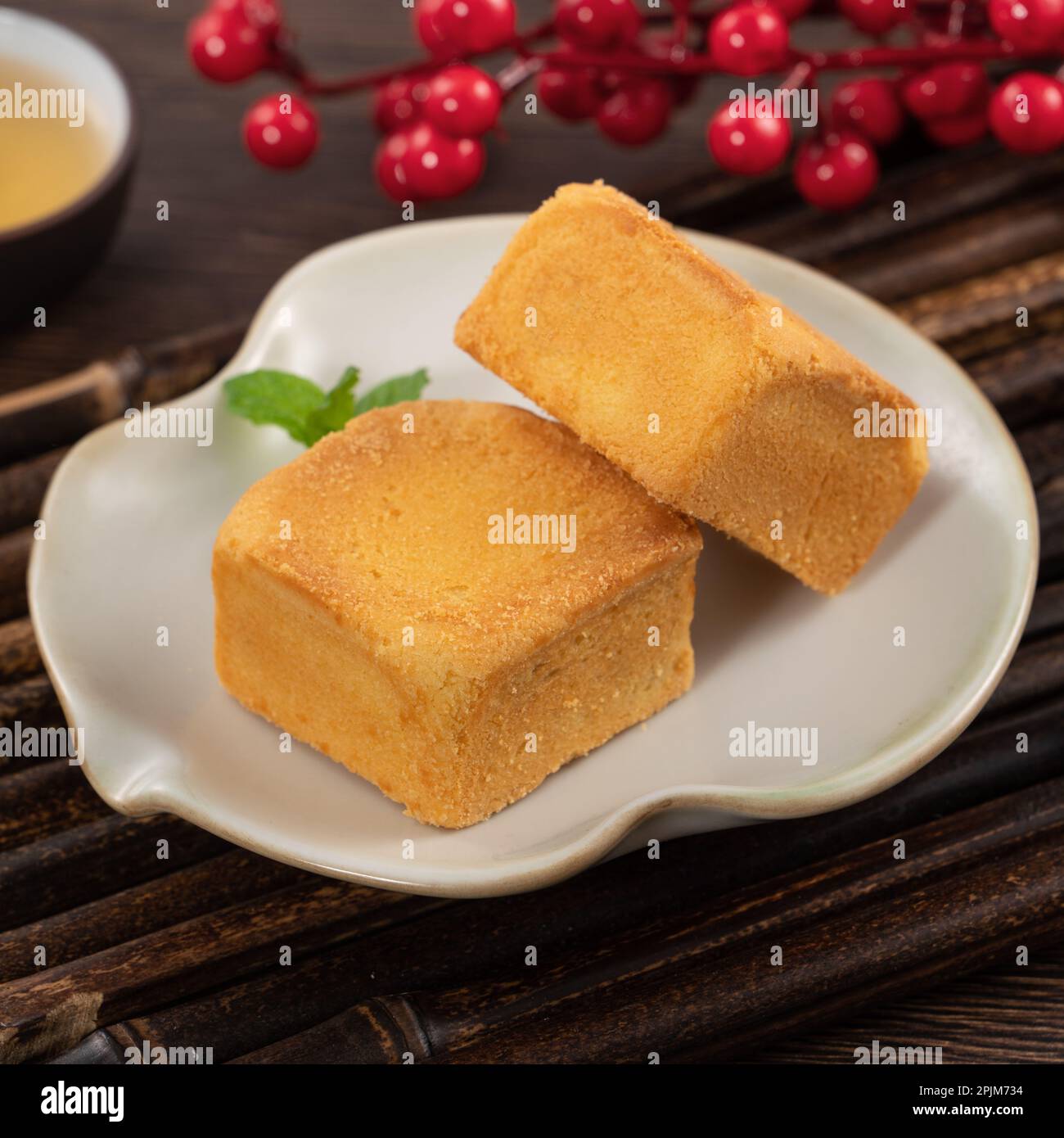 Delicious Taiwanese pineapple cake pastry dessert in a plate on wooden table background with hot tea. Stock Photo