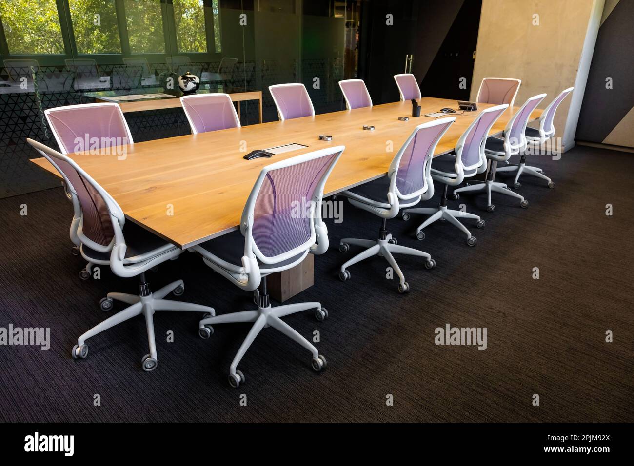 Empty executive boardroom with wooden table and fancy chairs on wheels Stock Photo