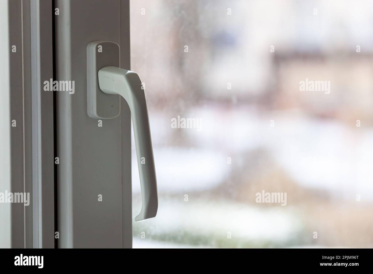 Closed white plastic pvc window in winter on a cloudy day. Photo in