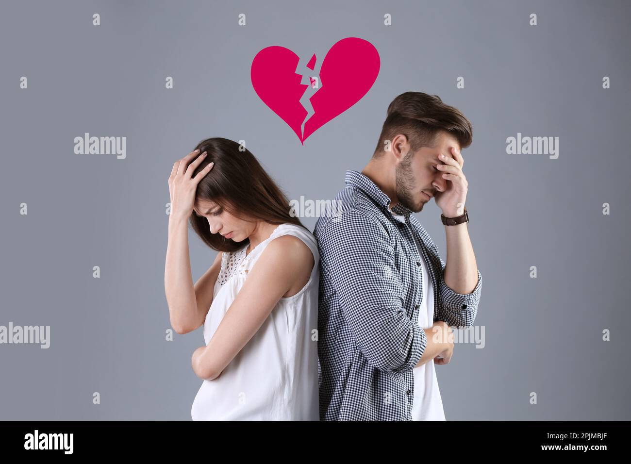 Upset young couple and illustration of broken heart on grey background. Relationship problems Stock Photo