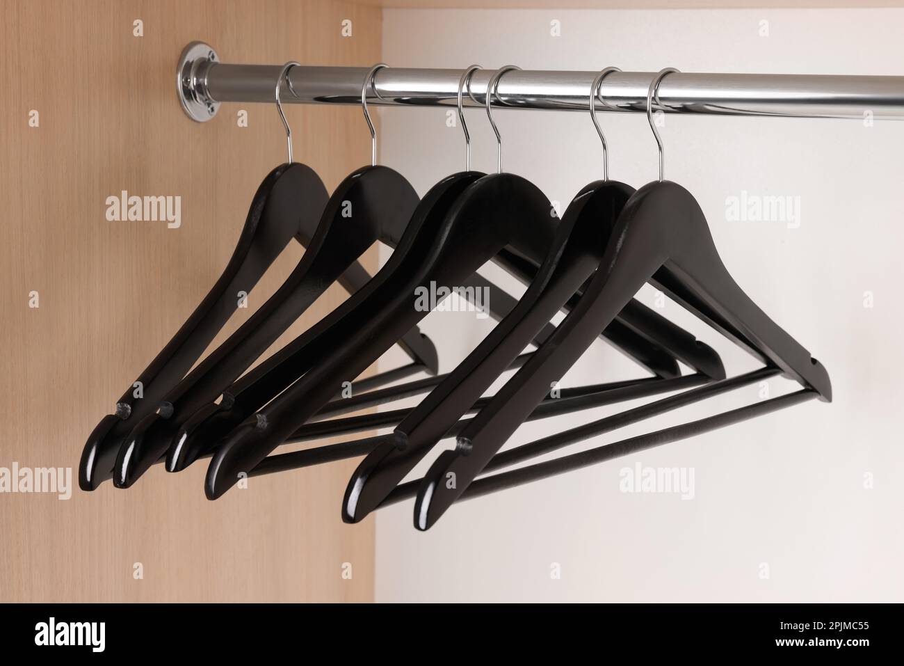 Set of black clothes hangers on wardrobe rail Stock Photo Alamy