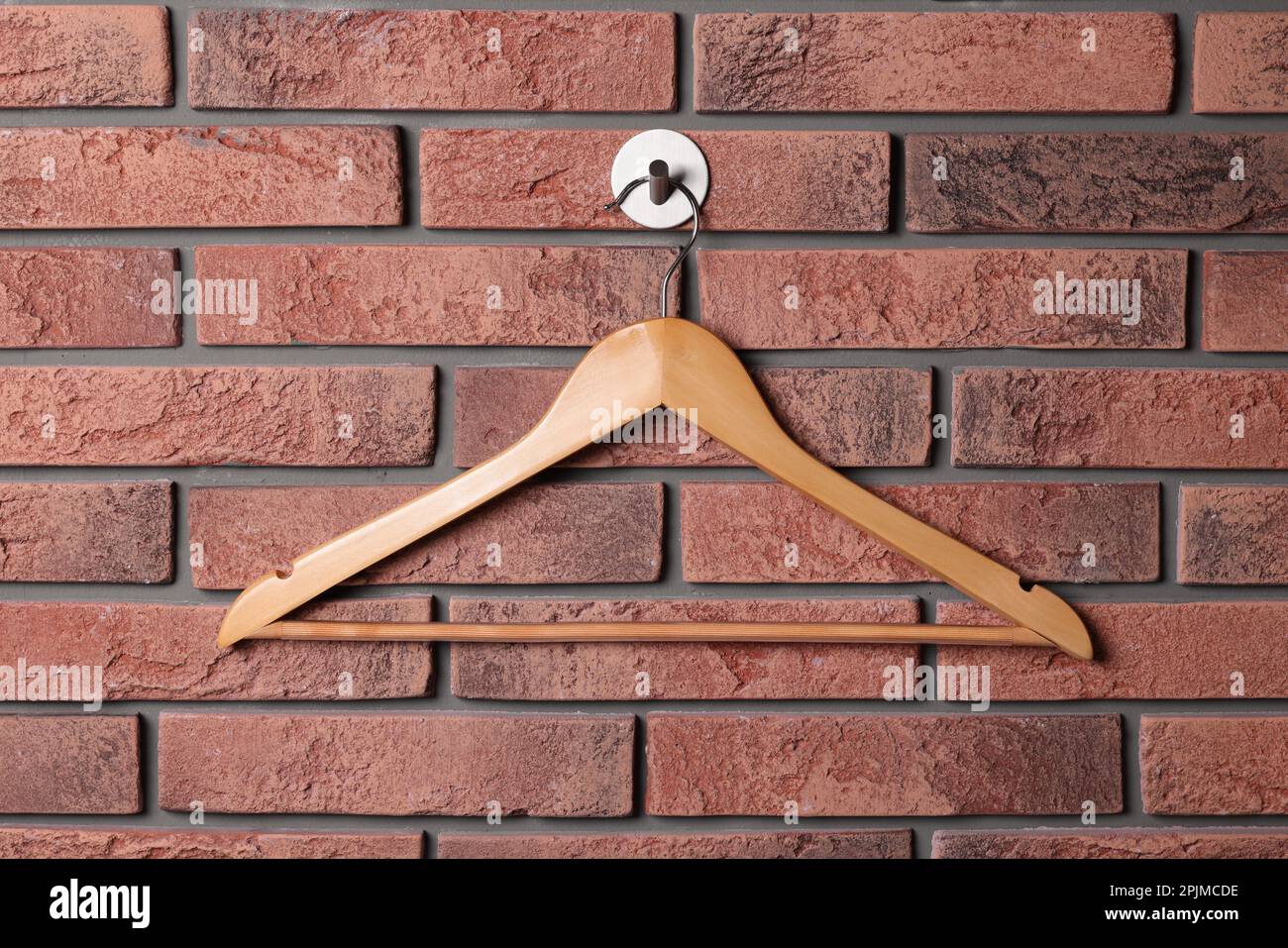 Wooden clothes hanger on red brick wall Stock Photo