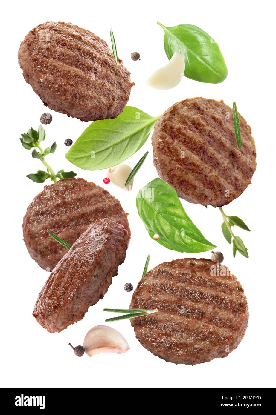 Tasty grilled hamburger patties and spices falling on white background