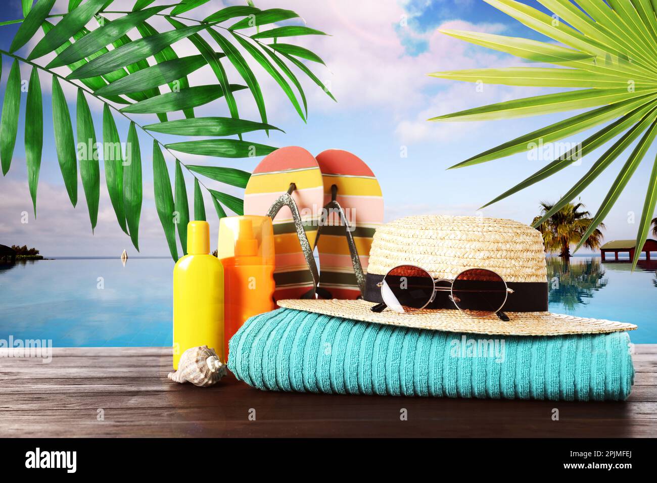 Different beach objects on wooden surface near outdoor swimming pool ...