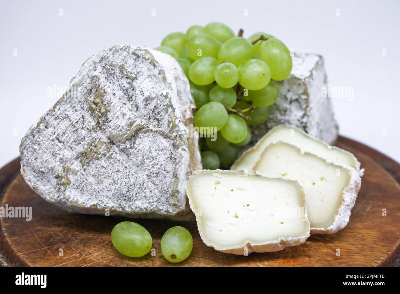 Assorted mouldy blue cheeses goat's milk on a wooden chopping board