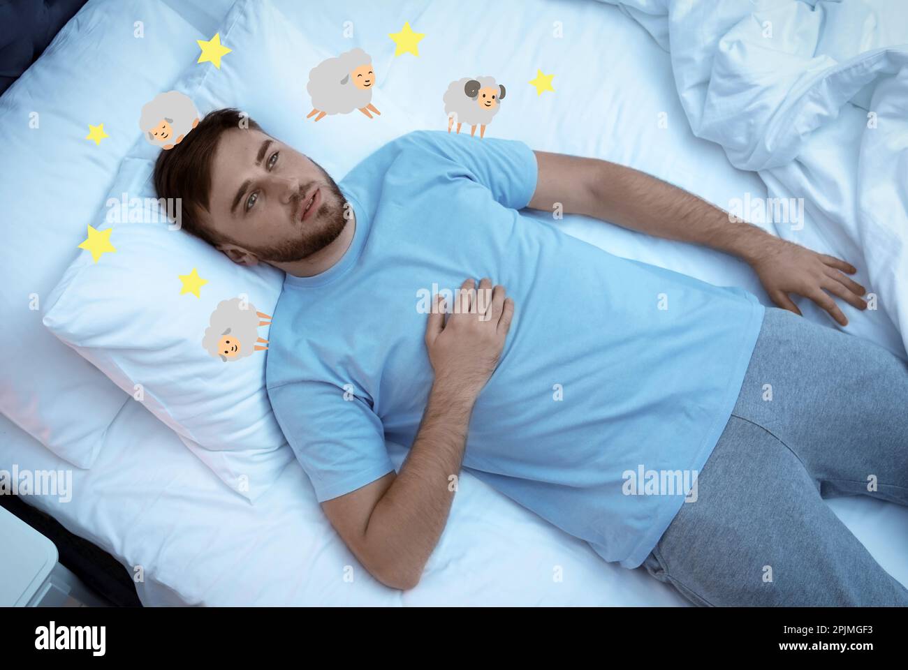Young man trying to fall asleep counting sheep in bed, above view Stock