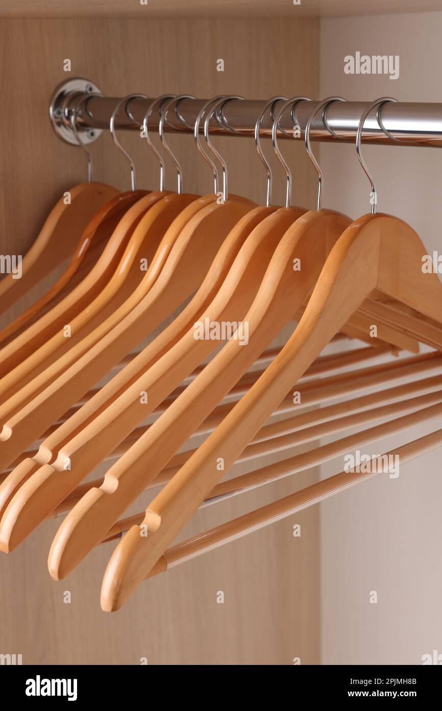 Set of clothes hangers on wardrobe rail, closeup Stock Photo