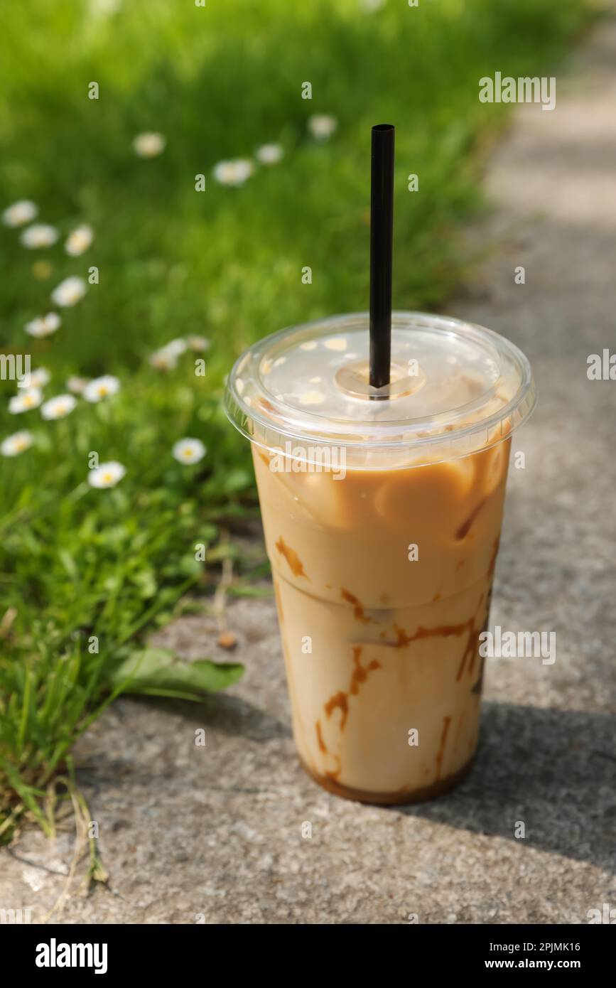 https://c8.alamy.com/comp/2PJMK16/takeaway-plastic-cup-with-cold-coffee-drink-and-straw-near-green-grass-outdoors-2PJMK16.jpg
