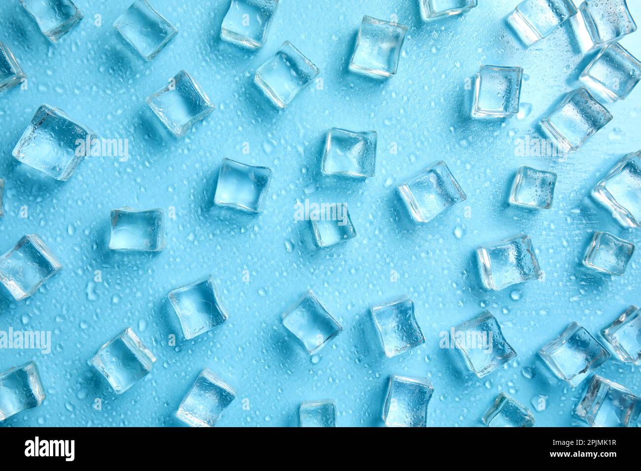 Cold ice and water drops on turquoise background, flat lay. Ingredient for refreshing drink Stock Photo