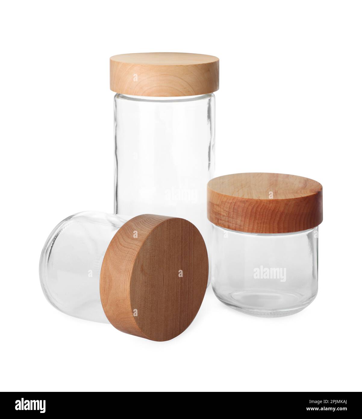 Three empty glass jars with wooden lids isolated on white Stock Photo