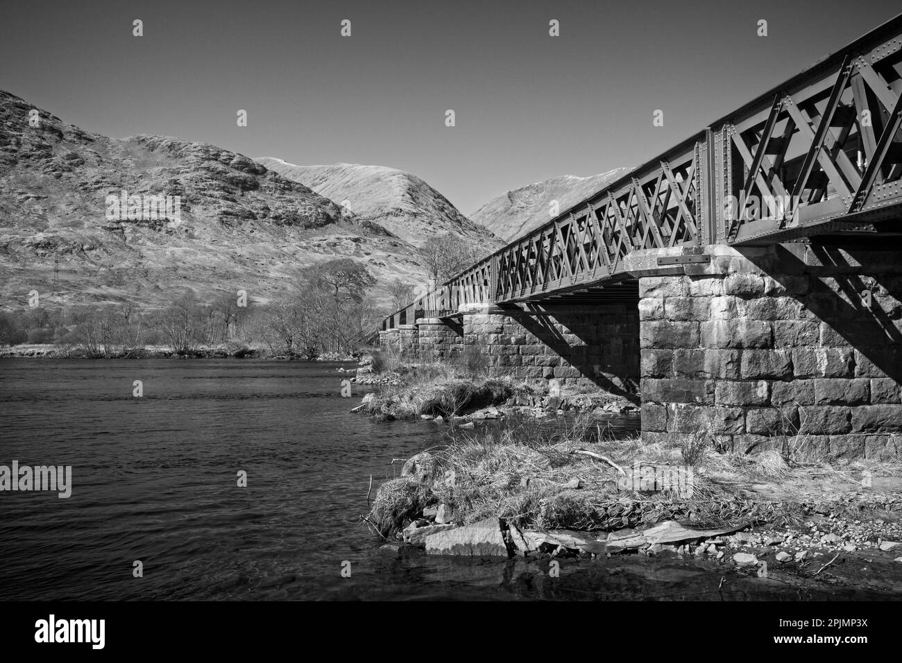 A green metal bridge crosses Loch Awe in the Scottish Highlands Stock