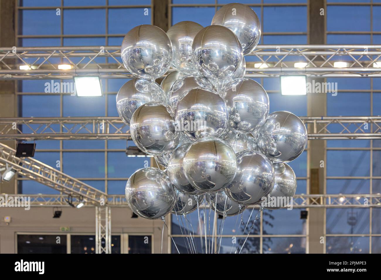 Cluster of Helium Filled Mylar Foil Silver Balloons at Stand in Hall Stock Photo