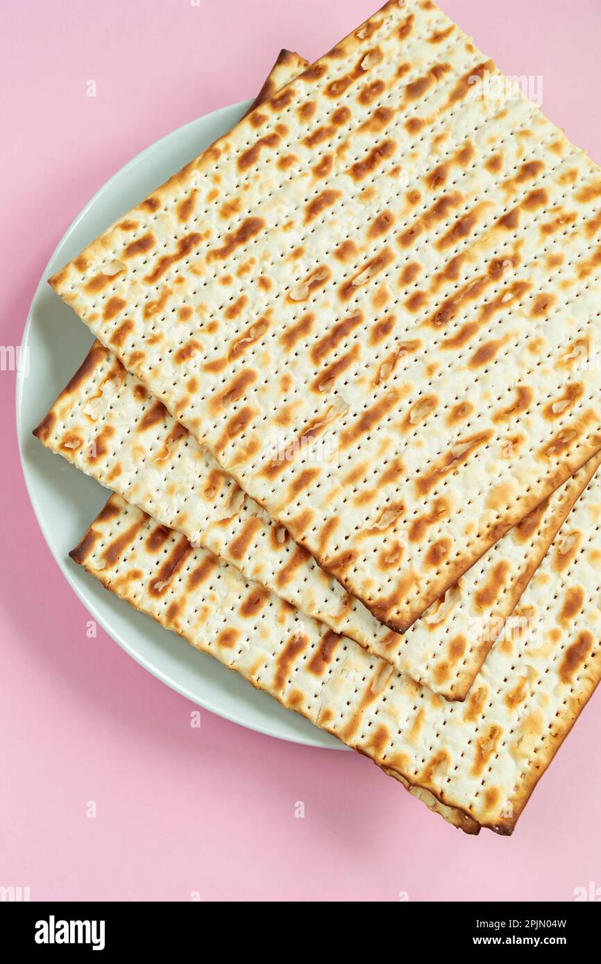 Traditional Jewish food matzo bread on pink background. Happy Passover. Religious spring holiday Pesach. Stock Photo