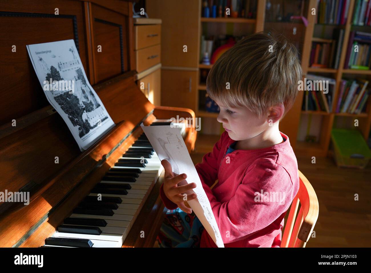 Boy learning to play the piano at home. Preschool education, child development concept Stock Photo