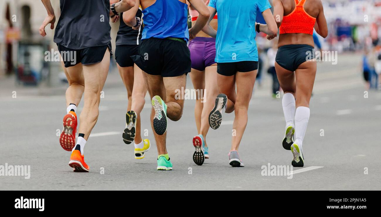 back legs group runners run marathon, female and male athletes jogging city race, sole running shoes Stock Photo