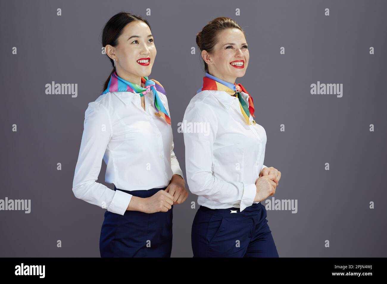 happy elegant female flight attendants in blue skirt, white shirt and