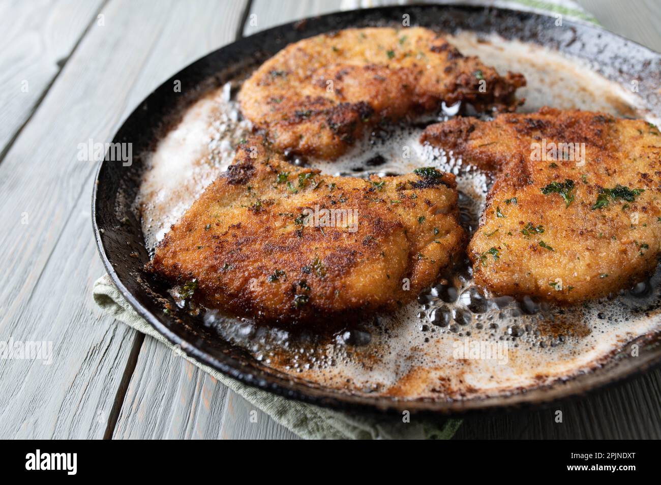 Parmesan breaded pork chops in a hot frying pan Stock Photo Alamy