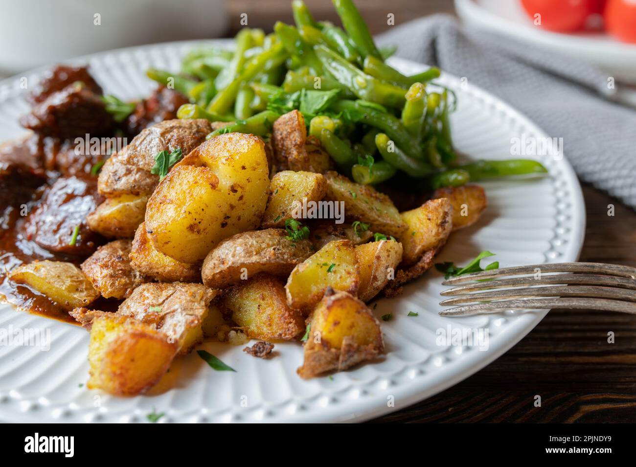 Pan fried potatoes on a dinner plate Stock Photo