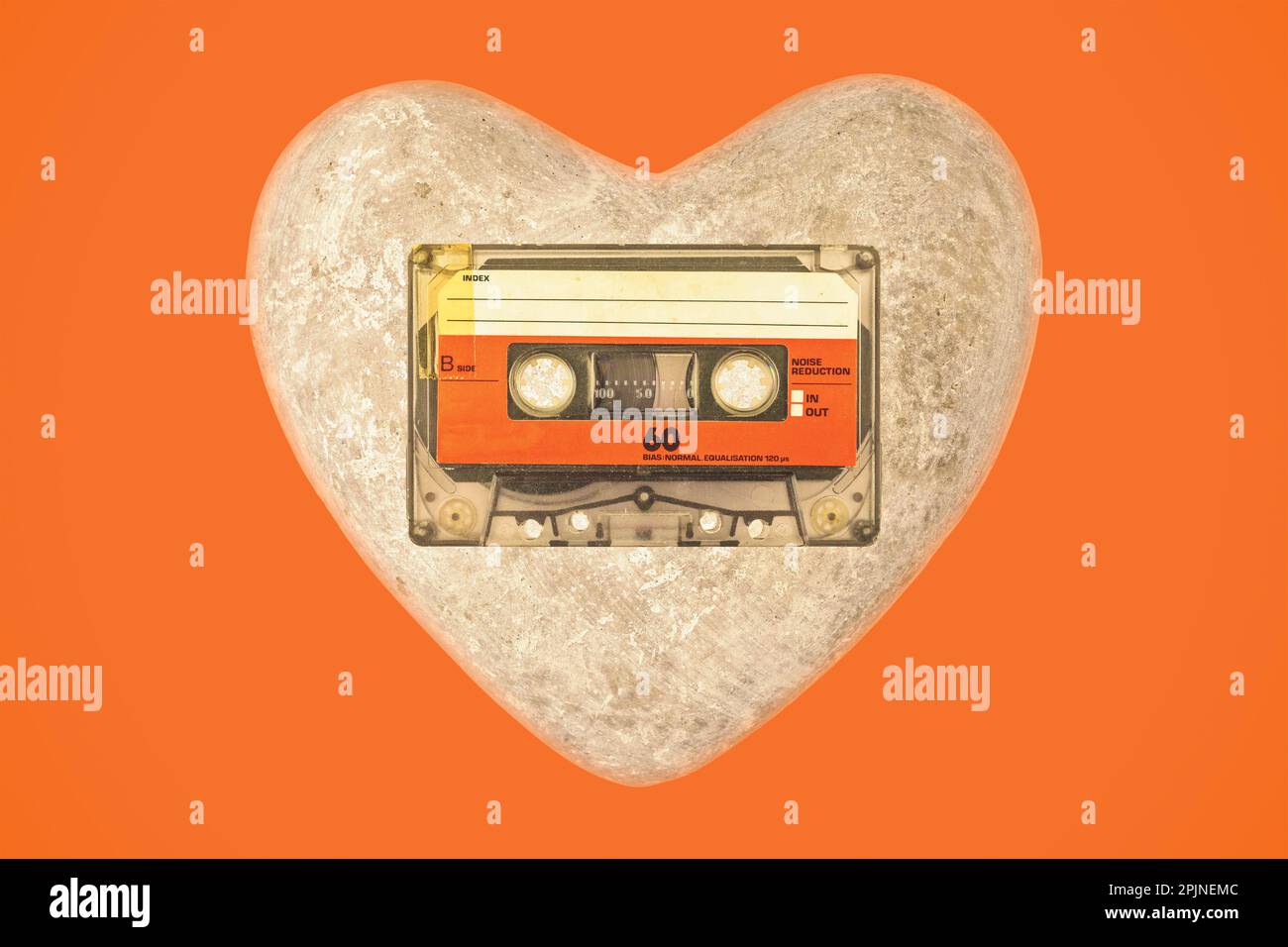 Vintage audio compact cassette with heart on an orange background Stock Photo
