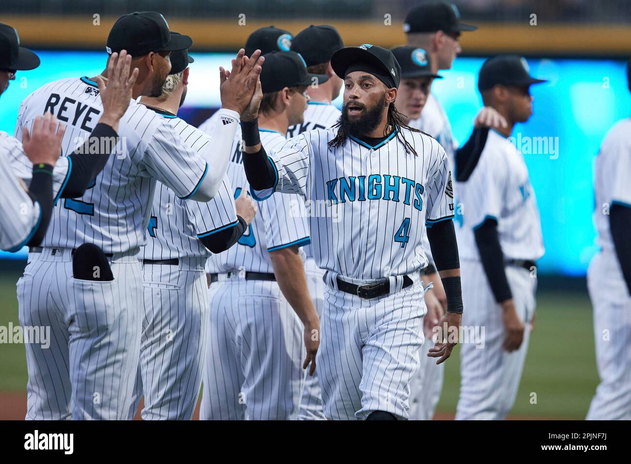 Billy Hamilton (4) of the Charlotte Knights high fives his teammates during  player introductions prior to the game against the Memphis Redbirds at  Truist Field on March 31, 2023 in Charlotte, North