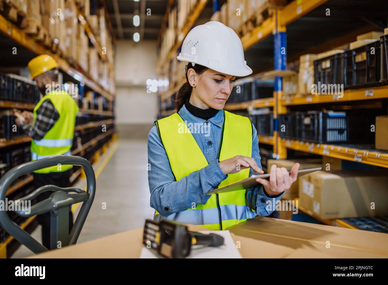 Warehouse workers checking stuff in warehouse with digital system in tablet, holding solar panel. Stock Photo