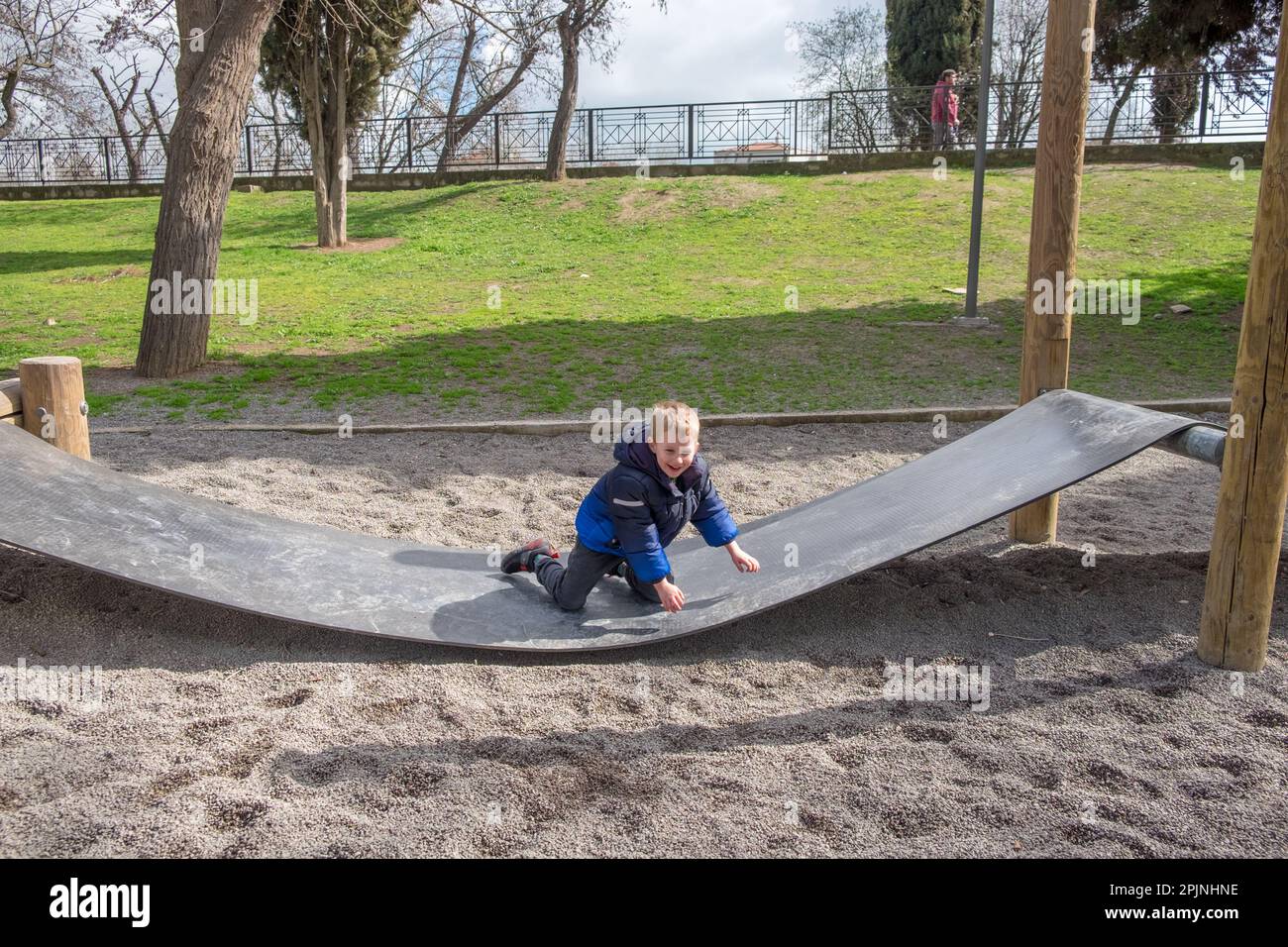 Cute little boy playing in a rubber bridge at the playground Stock Photo