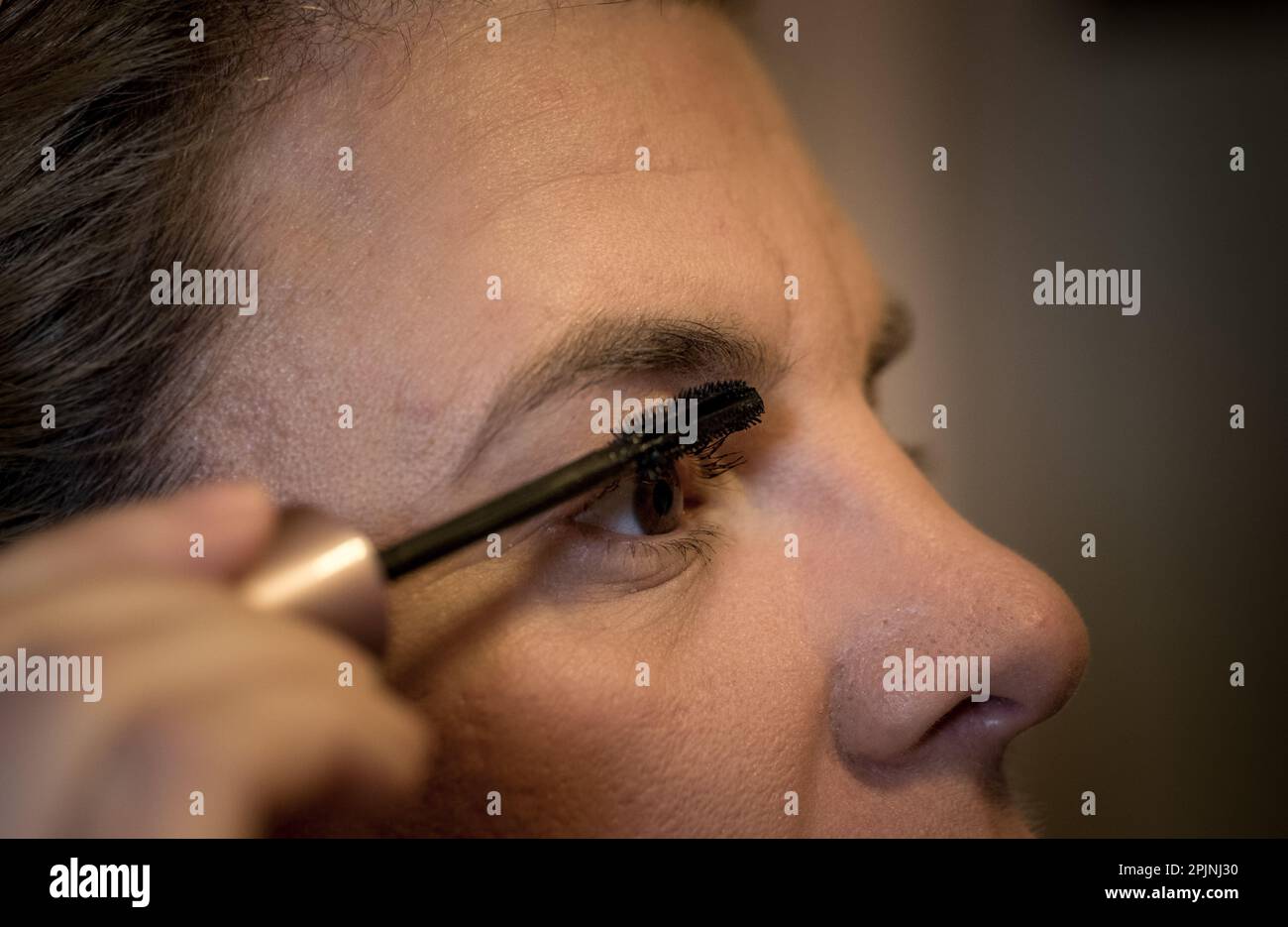 Adult woman applying an eye lash filler or eye brow filler Stock Photo