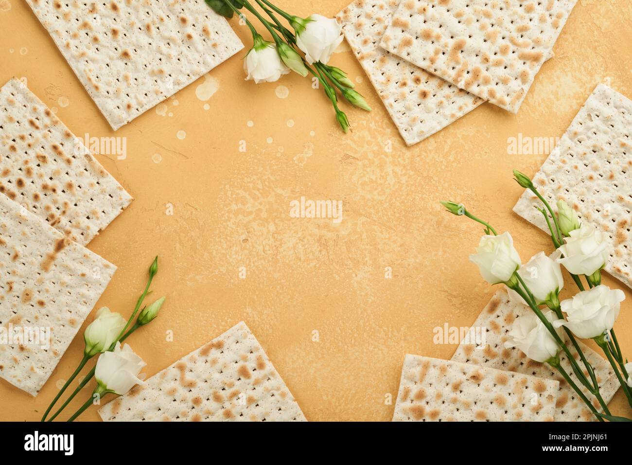 Matzah Passover celebration concept. Traditional ritual Jewish bread on sand color old wall background. Passover food. Pesach Jewish holiday of Passov Stock Photo