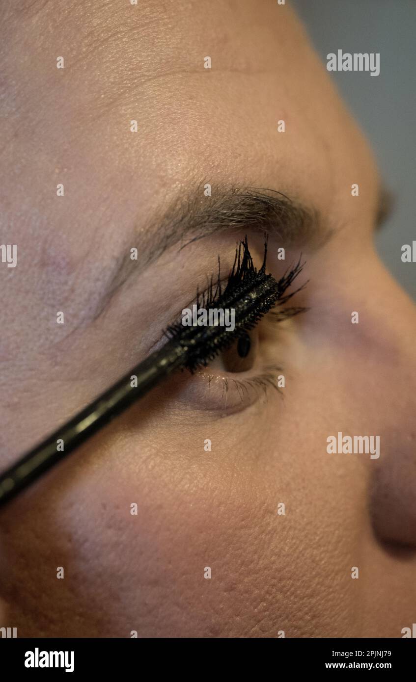 Adult woman applying an eye lash filler or eye brow filler Stock Photo